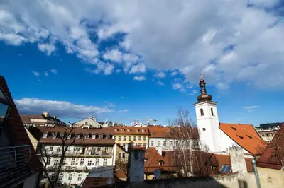 a building with a clock tower in a city at Ruterra Red Roofs View With Garage in Prague