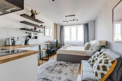 a small apartment with a bed and a kitchen at Ječná Stylish Residence - Charles Square, Old town in Prague
