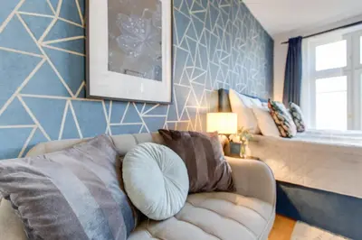 a living room with a couch and a wall at Ječná Stylish Residence - Charles Square, Old town in Prague