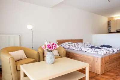 a room with a bed and a vase of flowers on a table at Apartmán IRIS Poděbrady 3 in Poděbrady