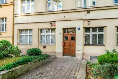 a building with a brown door and a brick sidewalk at Rentero Warm and Bright Apartment at Prague in Prague