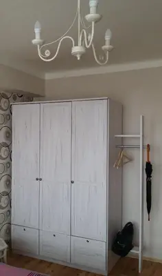 a white cabinet in a room with a chandelier at Veles Apartment in Prague