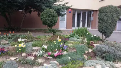 a garden of flowers in front of a building at Veles Apartment in Prague