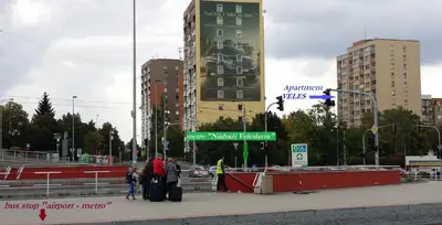 a group of people waiting at a bus stop in a city at Veles Apartment in Prague