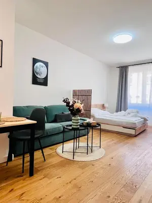 a living room with a green couch and a table at Studio above the Muzeum in Prague