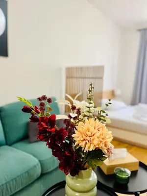 a vase with flowers on a table in a living room at Studio above the Muzeum in Prague