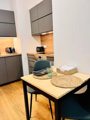 a kitchen with a wooden table with two chairs at Studio above the Muzeum in Prague