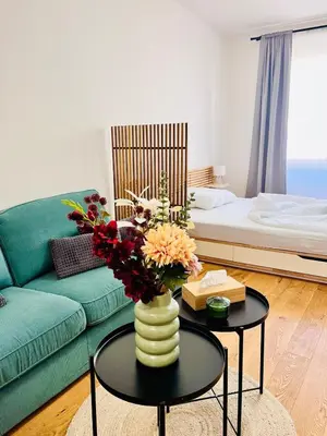 a living room with a couch and a vase with flowers on a table at Studio above the Muzeum in Prague