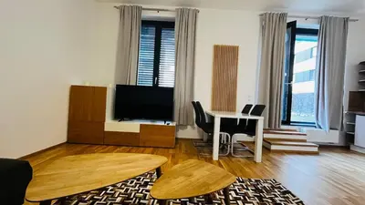 a living room with a television and a table with a desk at Apartment Holesovice, garden, garage in Prague