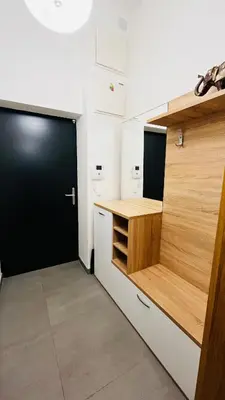 a small kitchen with a black door and white cabinets at Apartment Holesovice, garden, garage in Prague