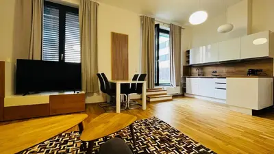 a living room with a television and a table with chairs at Apartment Holesovice, garden, garage in Prague