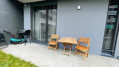 a patio with two chairs and a table and a grill at Apartment Holesovice, garden, garage in Prague