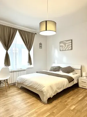 a white bedroom with a bed and a window at Entire apartment in the center of Prague in Prague