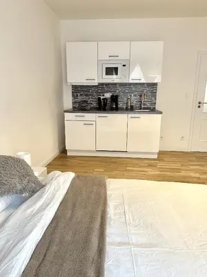 a bedroom with a white kitchen with a microwave at Entire apartment in the center of Prague in Prague