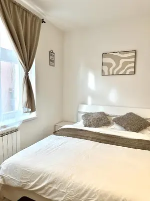 a white bedroom with a bed and a window at Entire apartment in the center of Prague in Prague