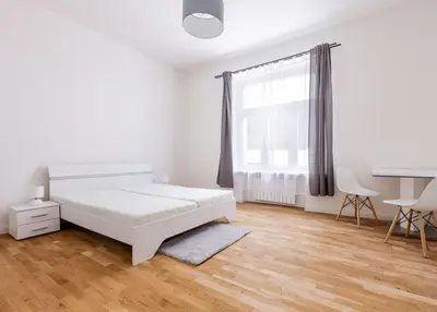 a white bedroom with a bed and a desk at Entire apartment in the center of Prague in Prague