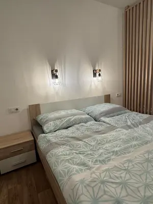 a bed in a bedroom with two lights on the wall at Diamond suite in Prague