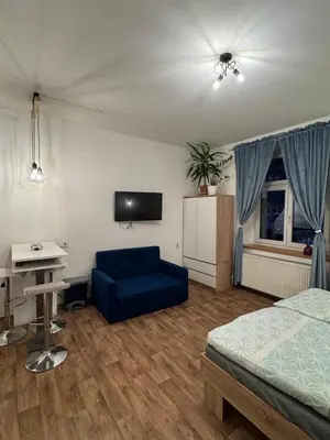 a bedroom with a blue couch and a tv at Diamond suite in Prague