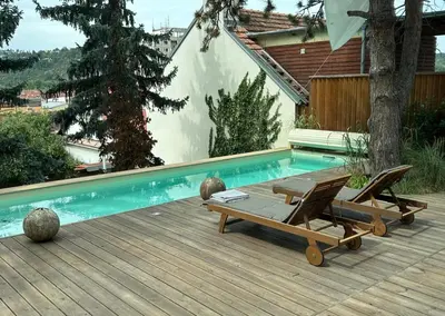 a swimming pool with two chairs and a table next to it at Prague Luxury Apartment in Prague