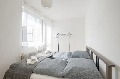 two beds in a white room with towels on them at Spacious House with Garden 15 min walk from Castle in Prague
