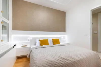 a white bedroom with a bed with yellow pillows at Residence near the Old Town Square in Prague