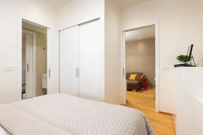 a white bedroom with a bed and a living room at Residence near the Old Town Square in Prague