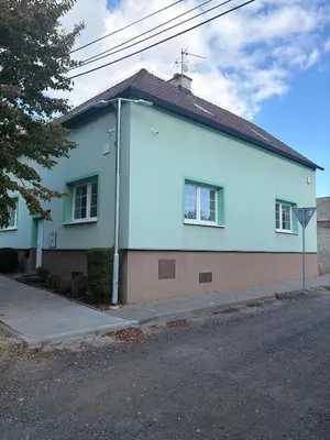 a blue house on the side of a street at Apartmán ve Zlonicích blízko Prahy in Zlonice