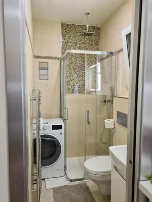a bathroom with a washing machine and a toilet at Fully renovated apartment by Anděl metro in Prague