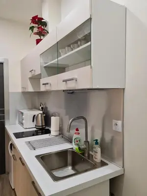 a kitchen with white cabinets and a sink at Fully renovated apartment by Anděl metro in Prague