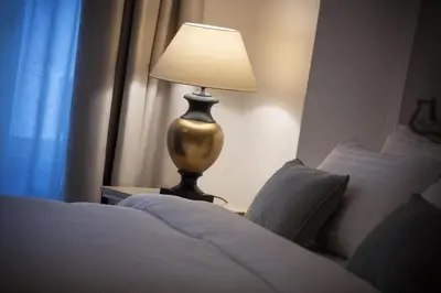 a lamp sitting on a table next to a bed at U Šuterů Boutique Hotel in Prague