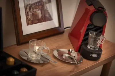 a table with a coffee maker and two glasses on it at U Šuterů Boutique Hotel in Prague