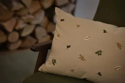 a pillow with butterflies on a green chair at U Šuterů Boutique Hotel in Prague