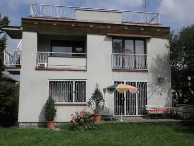 a white house with an umbrella in front of it at Pension Arcadia Prague in Prague