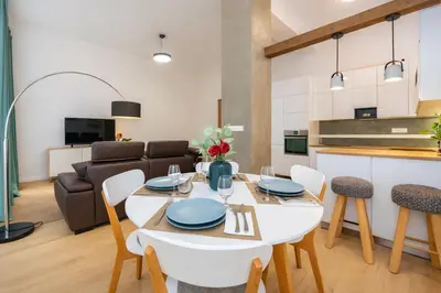 a kitchen and living room with a white table and chairs at Apartment Vinohradská 14 in Prague