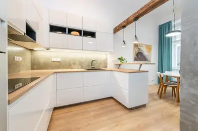 a kitchen with white cabinets and a table at Apartment Vinohradská 14 in Prague