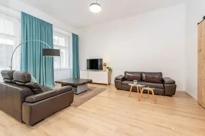 a living room with two leather couches and a television at Apartment Vinohradská 14 in Prague