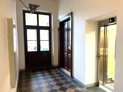 a hallway with two doors and a checkered floor at Small studio with loft bed in Prague