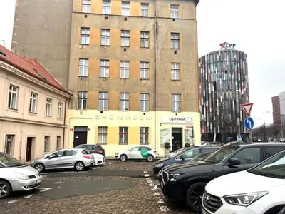 a parking lot with cars parked in front of a building at Small studio with loft bed in Prague
