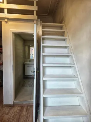 a staircase in a room with a door open at Small studio with loft bed in Prague
