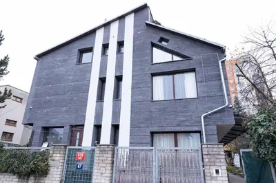 a gray house with a fence in front of it at Novohome in Prague
