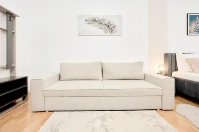 a living room with a white couch and a bed at Royal Apart in Prague
