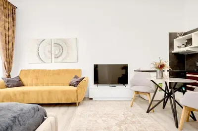 a living room with a yellow couch and a table at Royal Apart in Prague