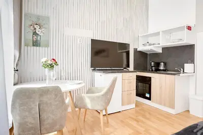 a kitchen with a table and two chairs and a television at Royal Apart in Prague