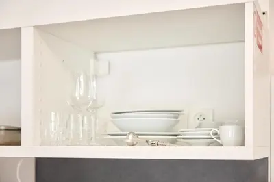 a white cabinet with a bunch of dishes in it at Royal Apart in Prague