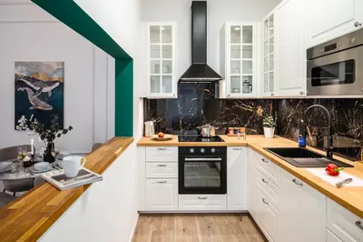 a kitchen with white cabinets and wooden counter tops at Prague Days - Two Bedroom Apartment with Parking and Netflix in Karlín in Prague