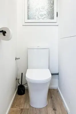 a white toilet in a bathroom with a picture on the wall at Prague Days - Two Bedroom Apartment with Parking and Netflix in Karlín in Prague