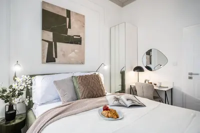 a white bedroom with a bed with a plate of food on it at Prague Days - Two Bedroom Apartment with Parking and Netflix in Karlín in Prague