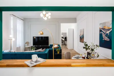 a living room with a blue couch and a table at Prague Days - Two Bedroom Apartment with Parking and Netflix in Karlín in Prague