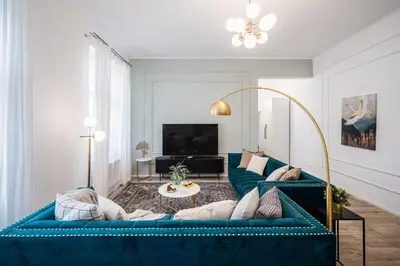 a living room with a blue couch and a tv at Prague Days - Two Bedroom Apartment with Parking and Netflix in Karlín in Prague