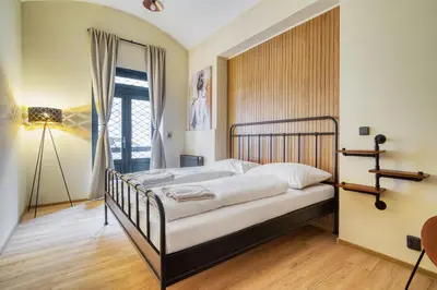 a bedroom with a bed and a window at KYRA Apartments by Rentez in Prague